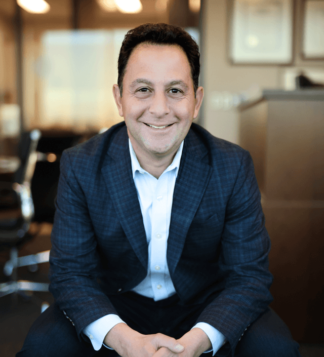 Peter Mallouk in business casual attire smiling at the camera.